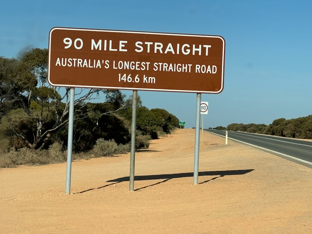 a sign on the side of a road that says 90 mile straight