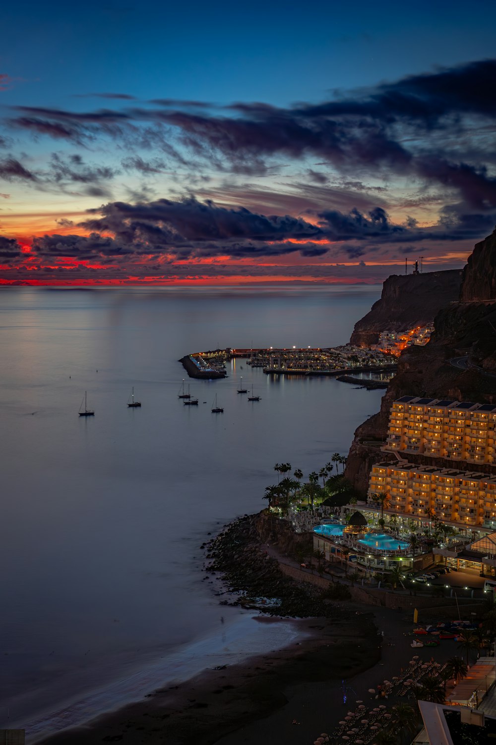 a beautiful sunset over the ocean with boats in the water