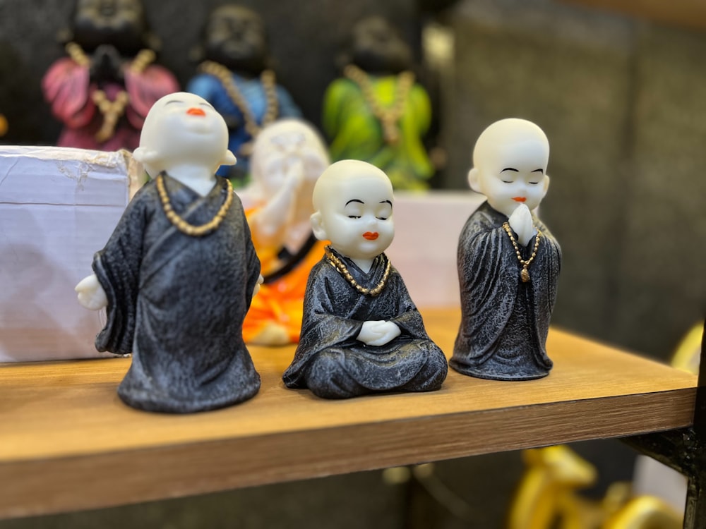 Eine Gruppe kleiner Buddha-Figuren, die auf einem Holztisch sitzen