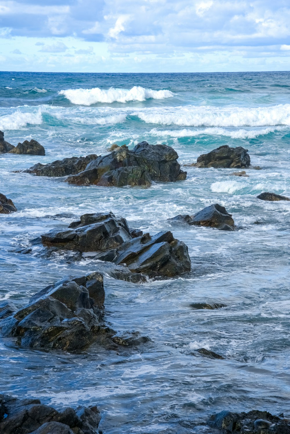 a person standing on rocks near the ocean