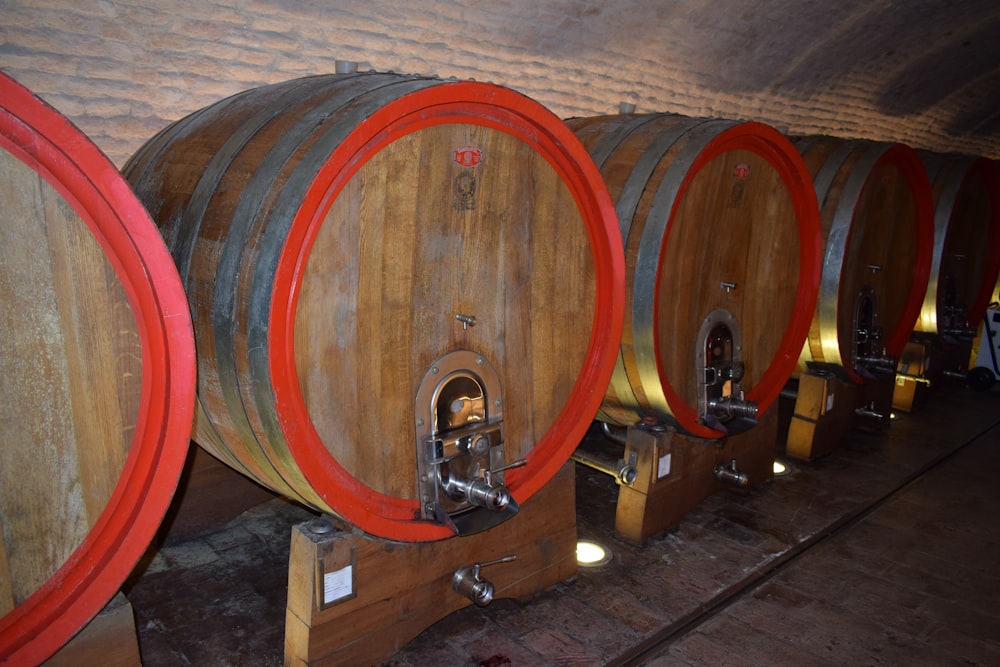 a row of wine barrels lined up in a cellar