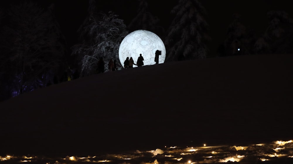 un gruppo di persone in piedi sulla cima di una collina innevata