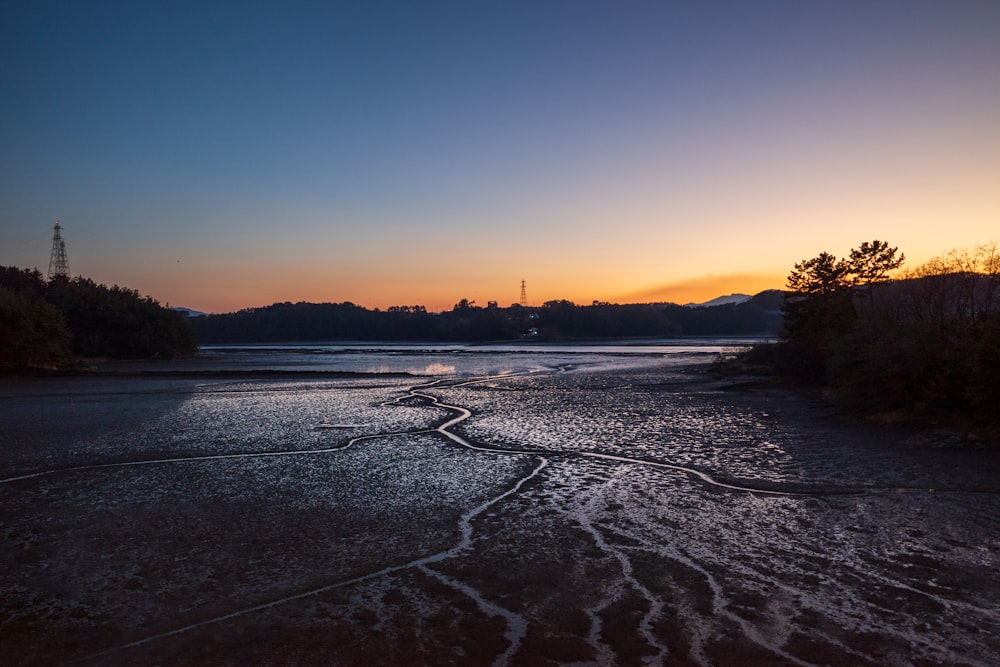 il sole sta tramontando su uno specchio d'acqua