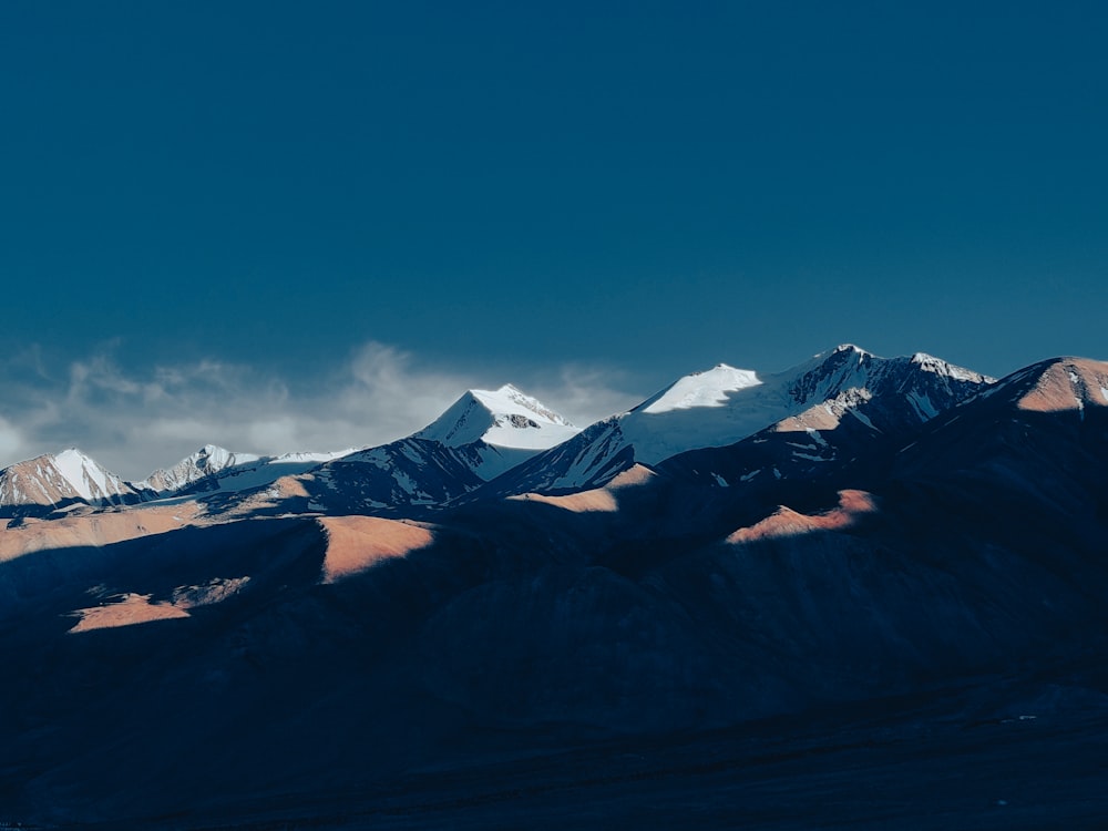 a mountain range with snow capped mountains in the background