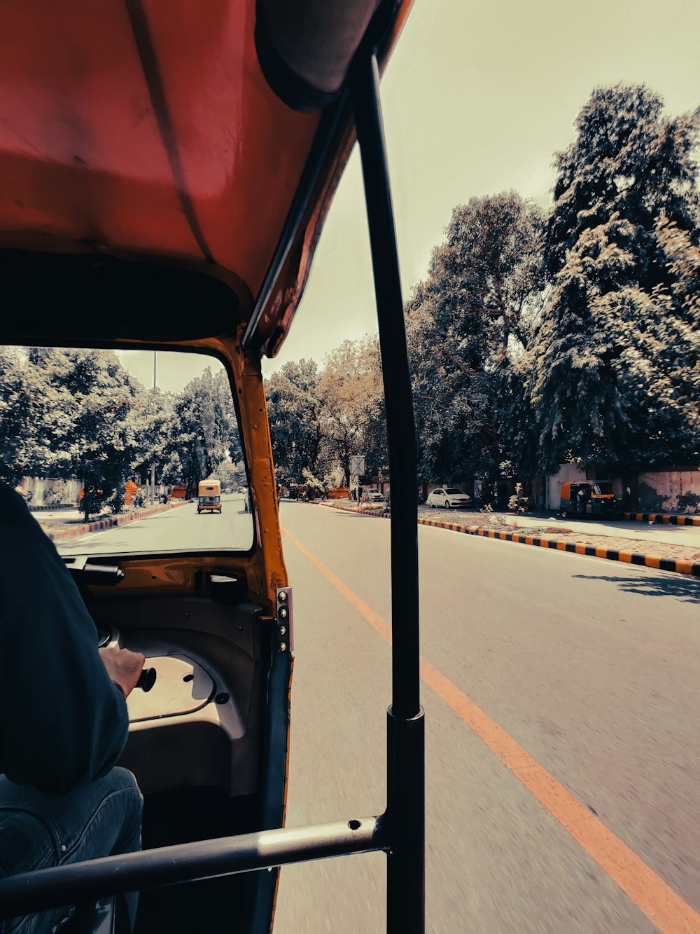 a man driving a red truck down a street