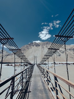 a wooden bridge with a mountain in the background