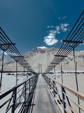 a wooden bridge with a mountain in the background