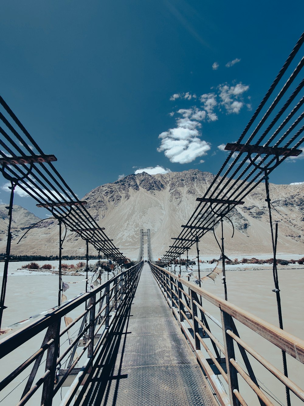 a wooden bridge with a mountain in the background