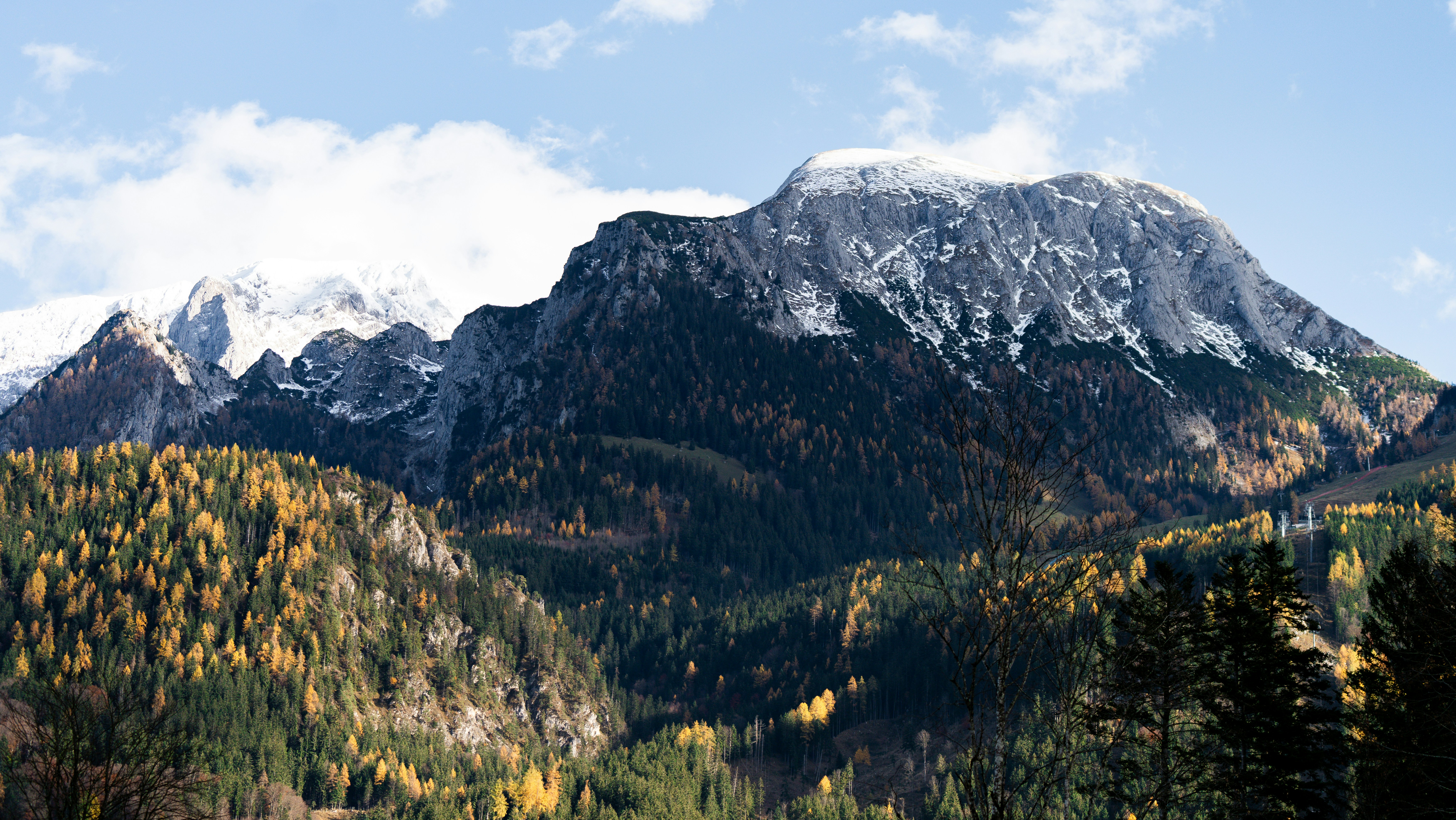 a view of a mountain range with trees in the foreground