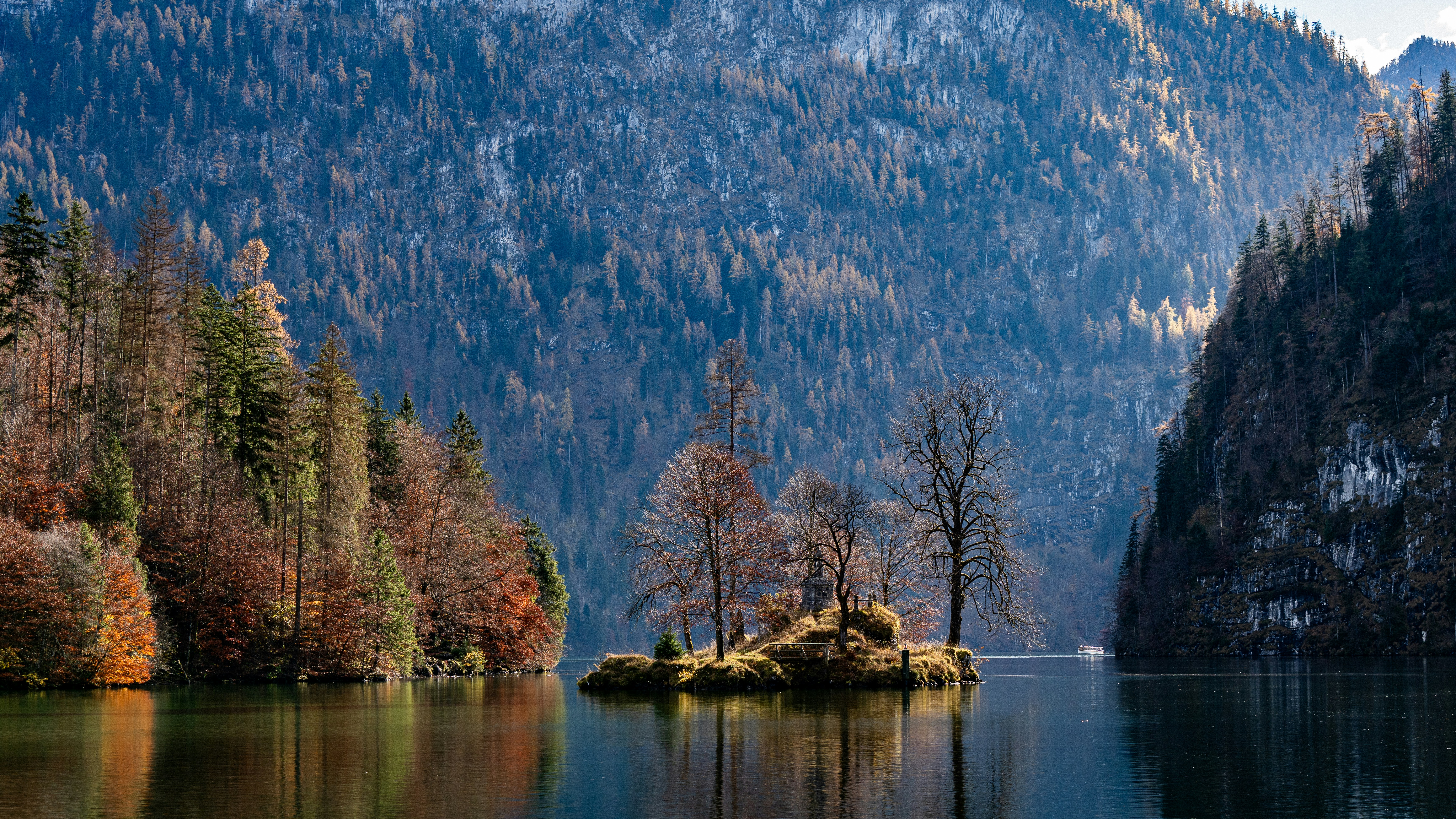 a small island in the middle of a lake surrounded by mountains