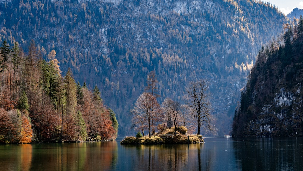 a small island in the middle of a lake surrounded by mountains