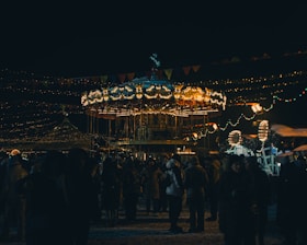 a crowd of people standing around a merry go round