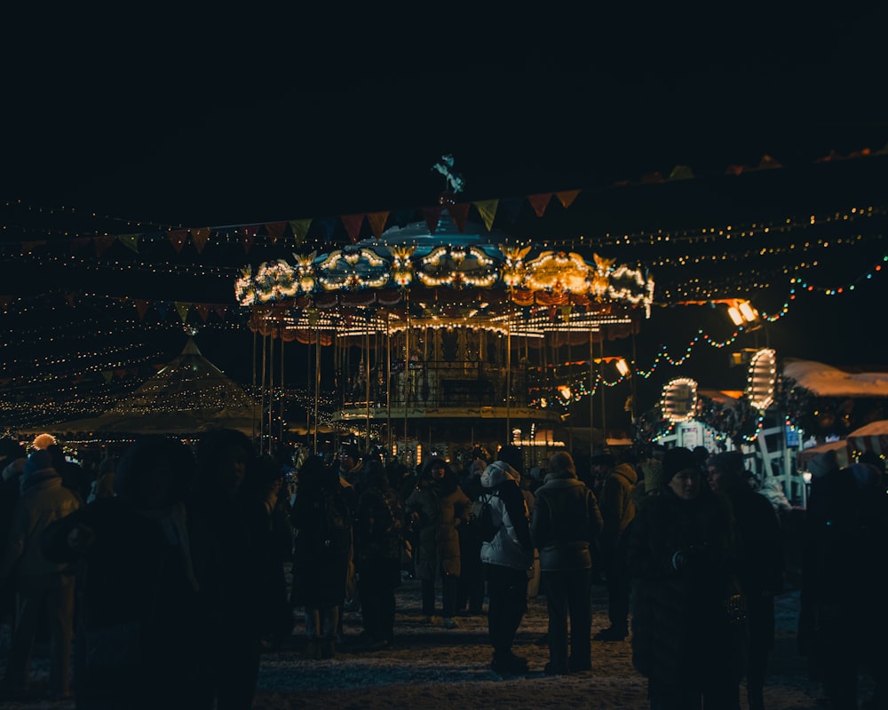 a crowd of people standing around a merry go round