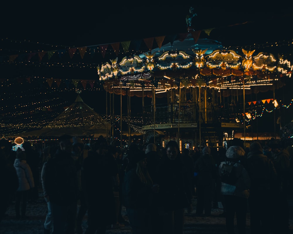 a group of people standing around a merry go round