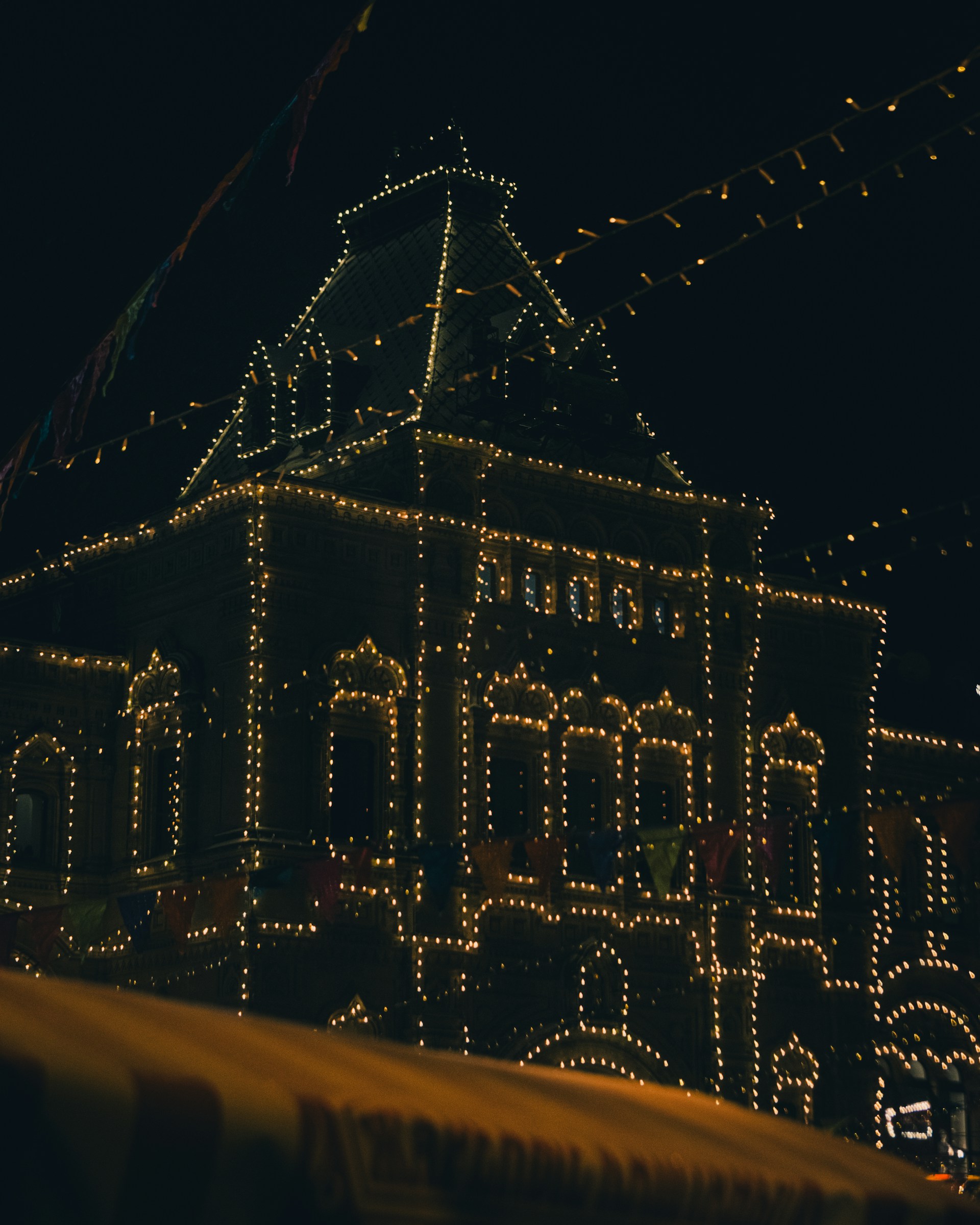 a large building with a clock tower covered in christmas lights