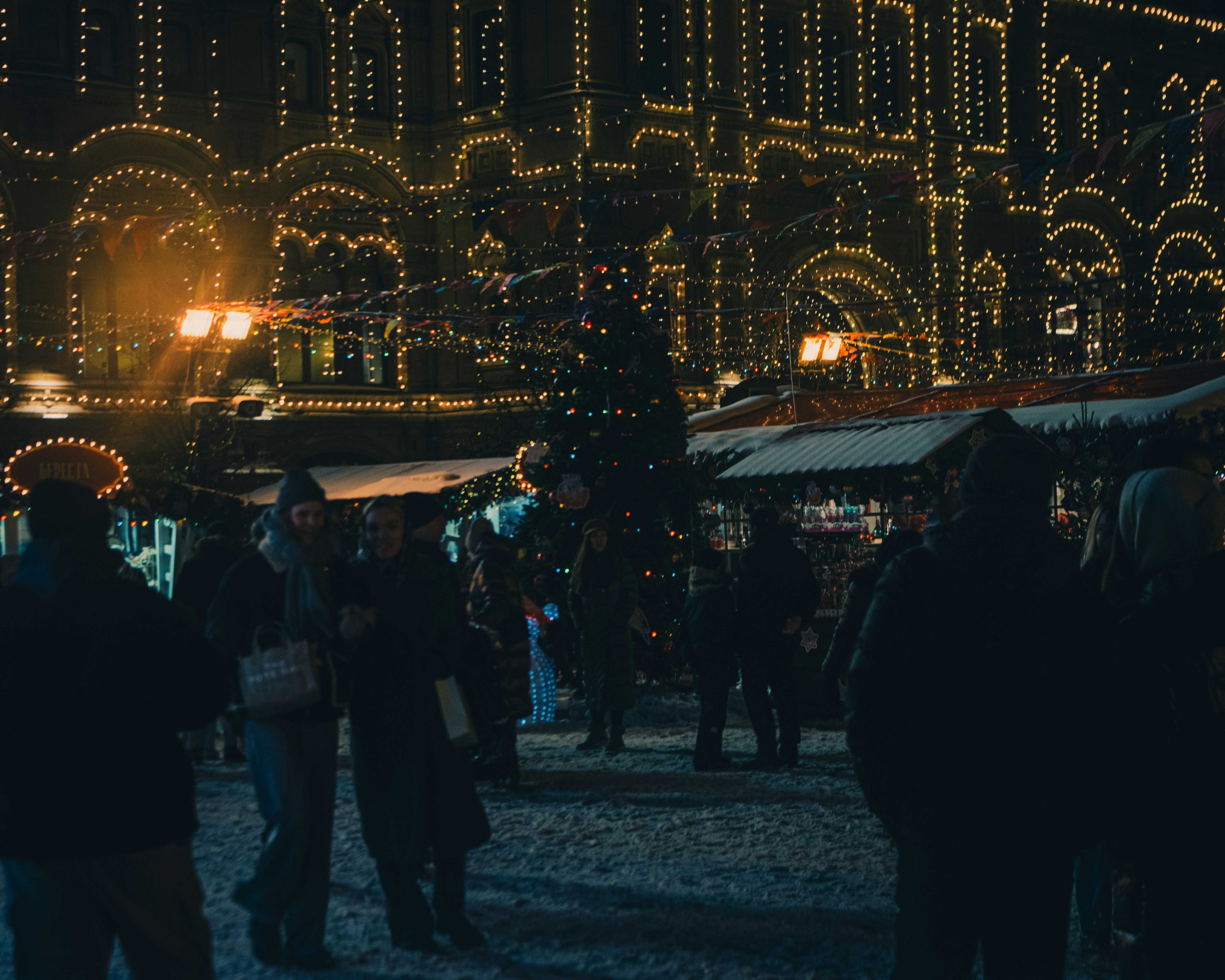 a crowd of people standing around a christmas tree
