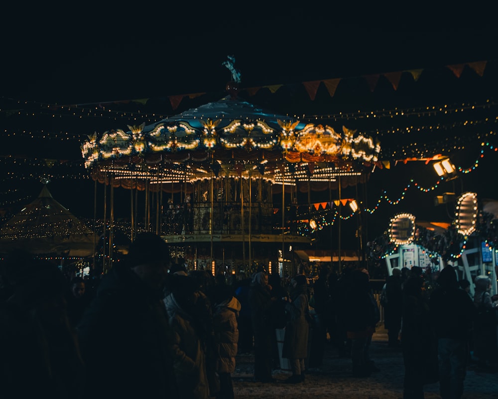 a crowd of people standing around a merry go round