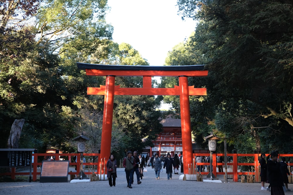 a group of people walking under an orange tori tori tori tori tori tori tori tori