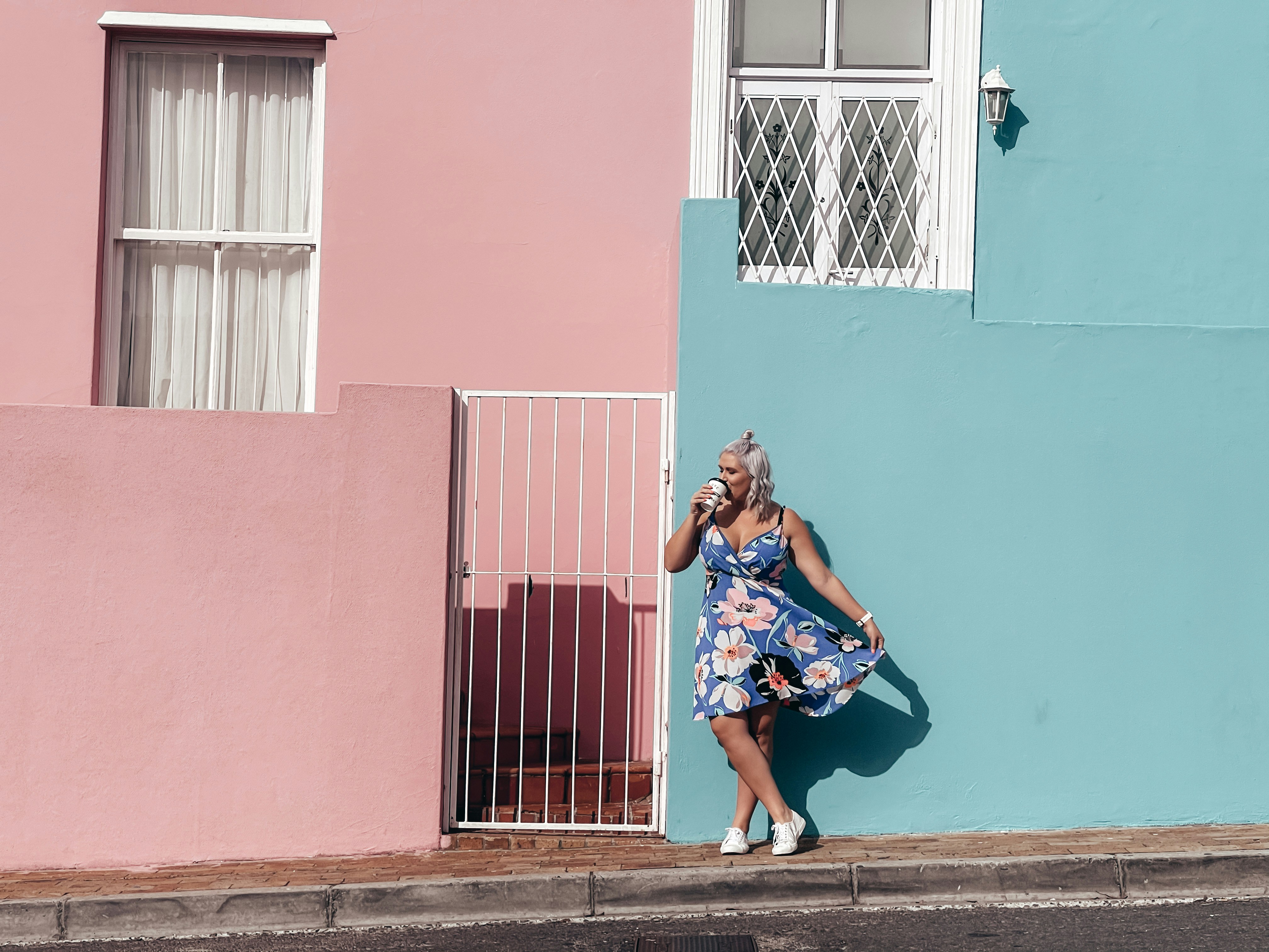 a woman leaning against a wall talking on a cell phone