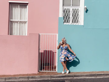 a woman leaning against a wall talking on a cell phone
