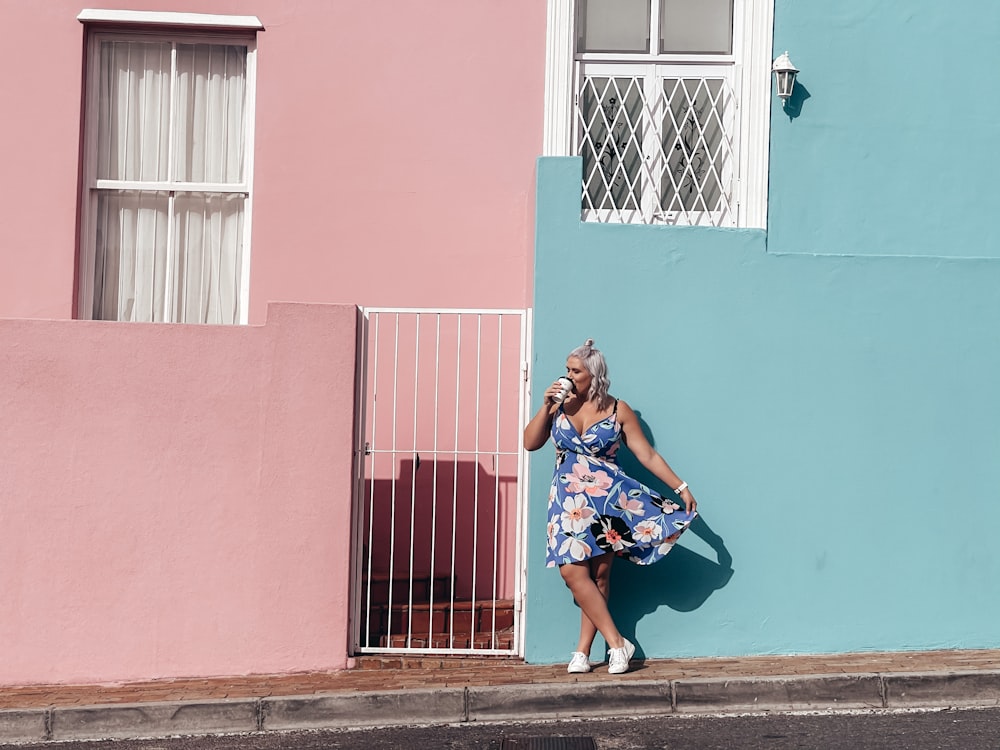 a woman leaning against a wall talking on a cell phone