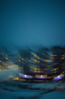 Evening view of a residential building with warm lights glowing from windows.