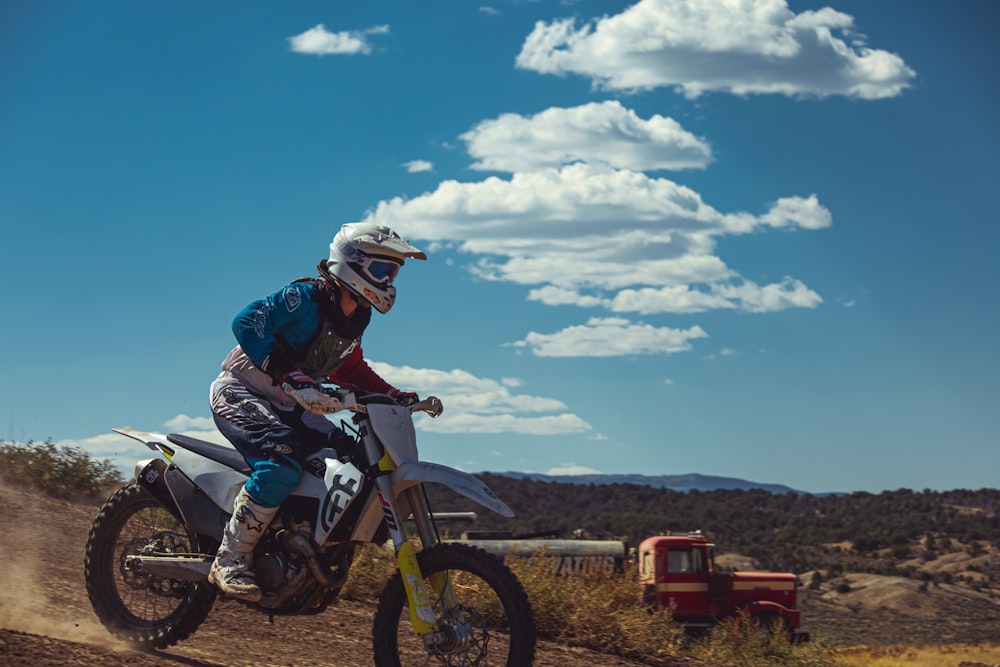 un homme conduisant une moto tout-terrain sur un chemin de terre