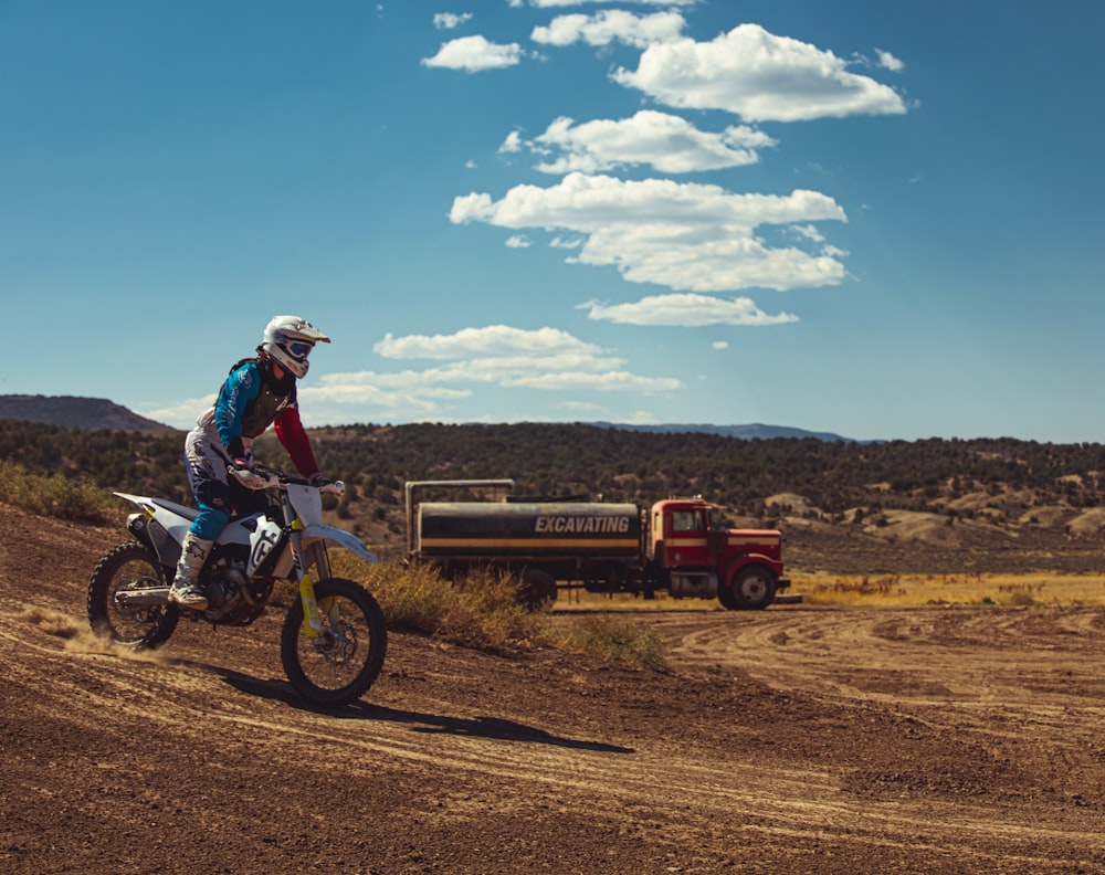 a man riding a dirt bike on top of a dirt field