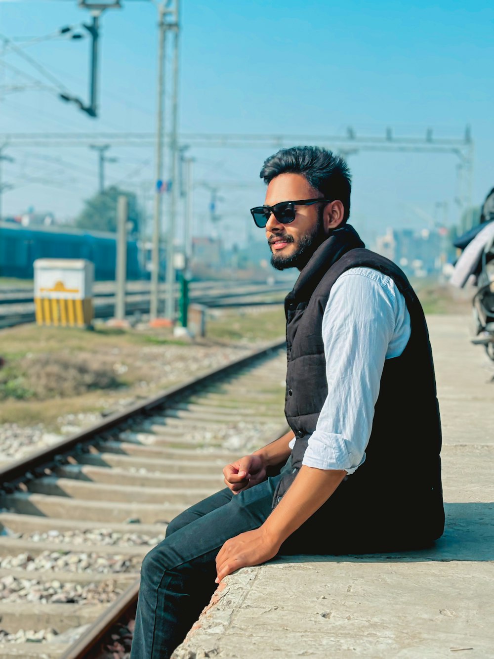 a man sitting on a rail road track