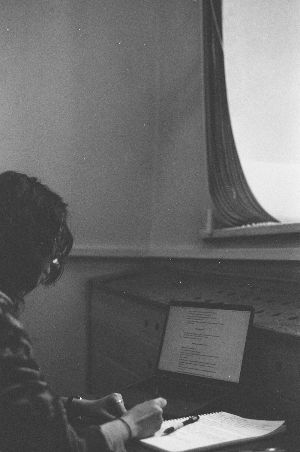 a person sitting at a desk with a laptop