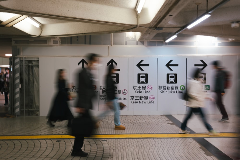 a group of people walking past a subway station