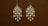 Two intricately designed chandelier earrings feature multiple white pearls set in a gold frame against a plain brown background.