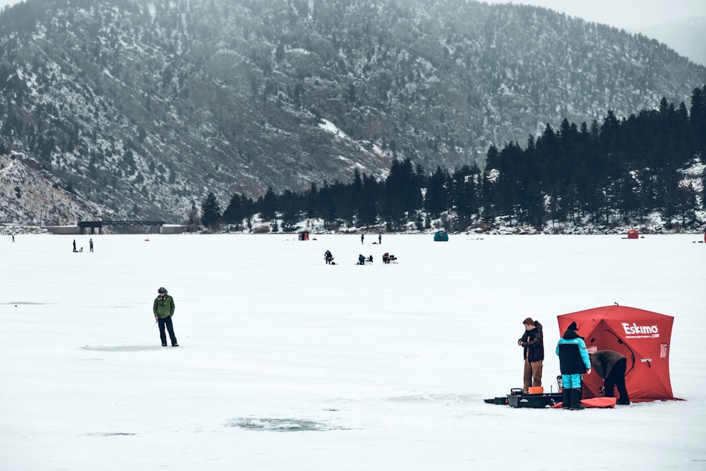 a group of people standing on top of a snow covered field