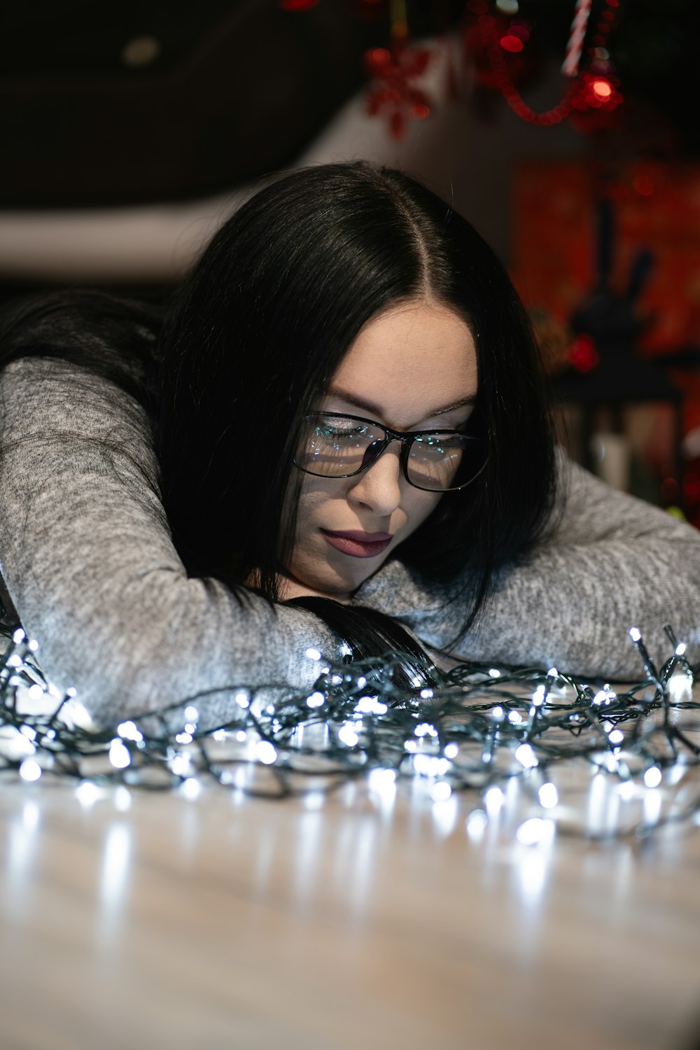 a woman laying on a table covered in christmas lights