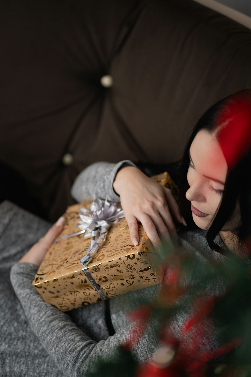 a woman laying on a couch holding a wrapped present