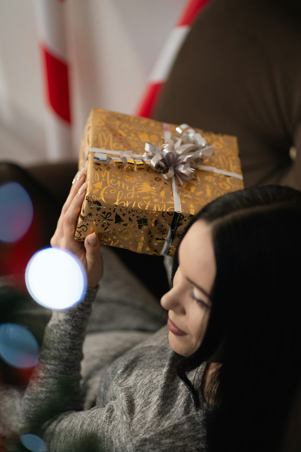a woman sitting on a couch holding a wrapped present