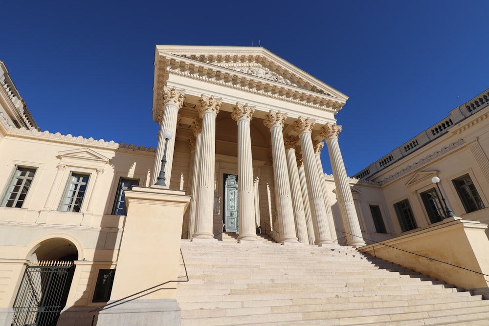 un grand bâtiment avec des colonnes et une tour de l’horloge