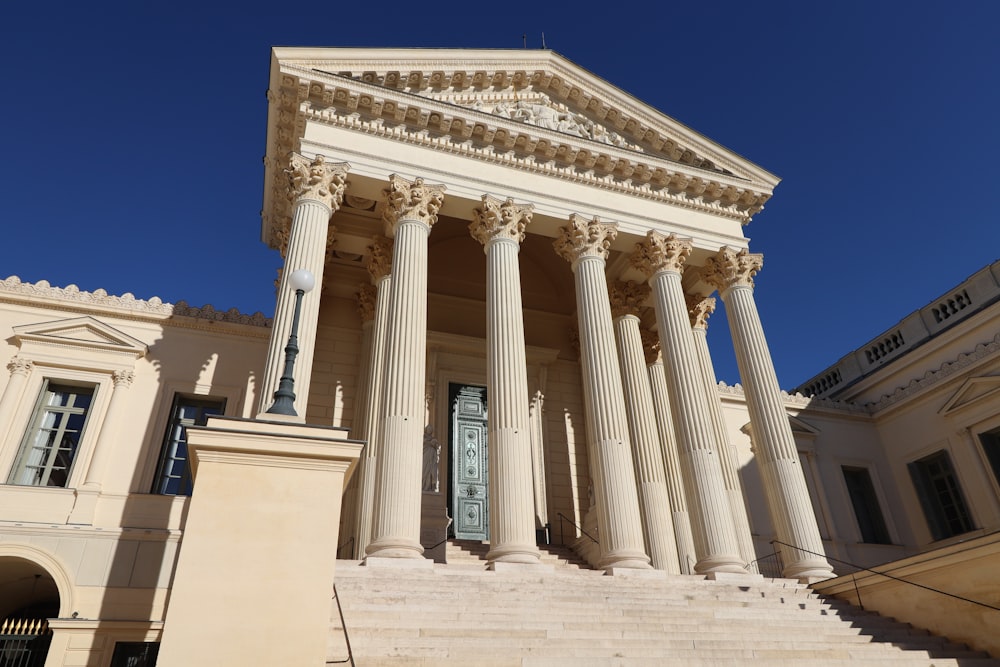 a building with columns and a clock on the front of it