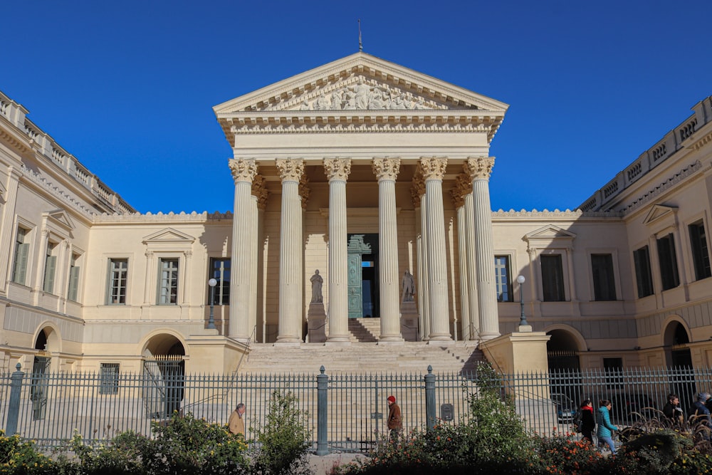 un grand bâtiment entouré de colonnes et d’une clôture