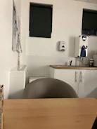A clean and organized office break room with freshly wiped surfaces and stocked supplies