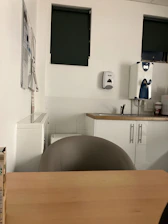 A clean and organized office break room with freshly wiped surfaces and stocked supplies