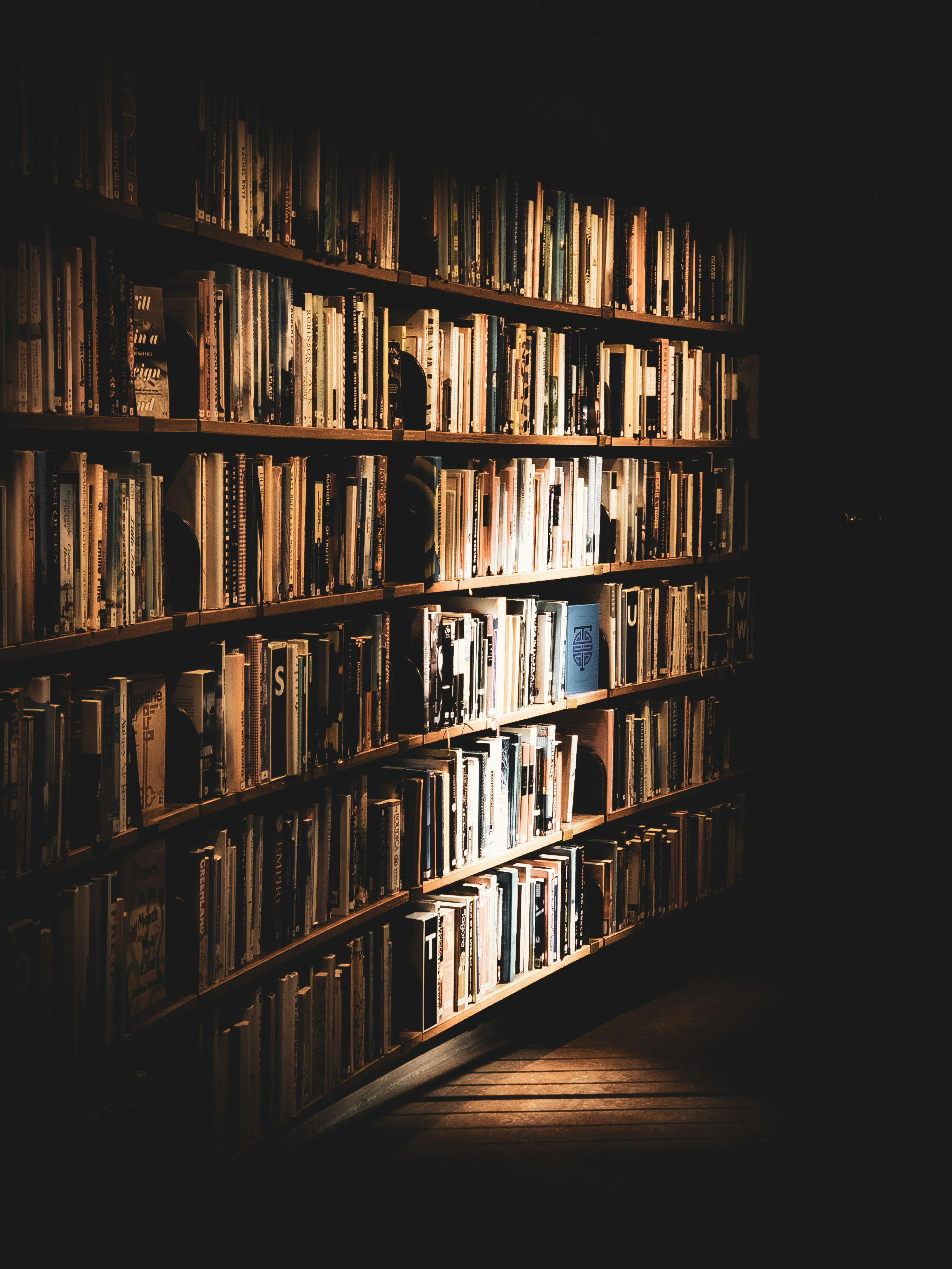 a bookshelf filled with lots of books in a dark room