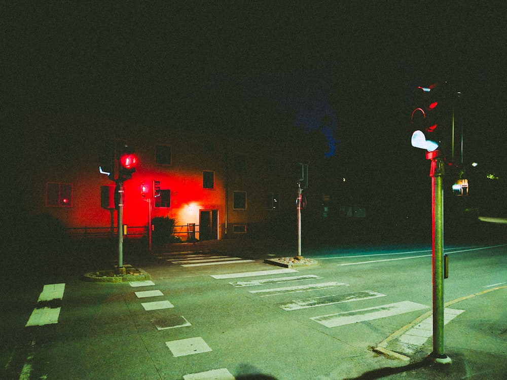 a street at night with a red traffic light