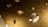 Numerous floating or levitating diamonds, cut in various shapes, with a glimmering, reflective quality. The background has a textured, gold-hued appearance.