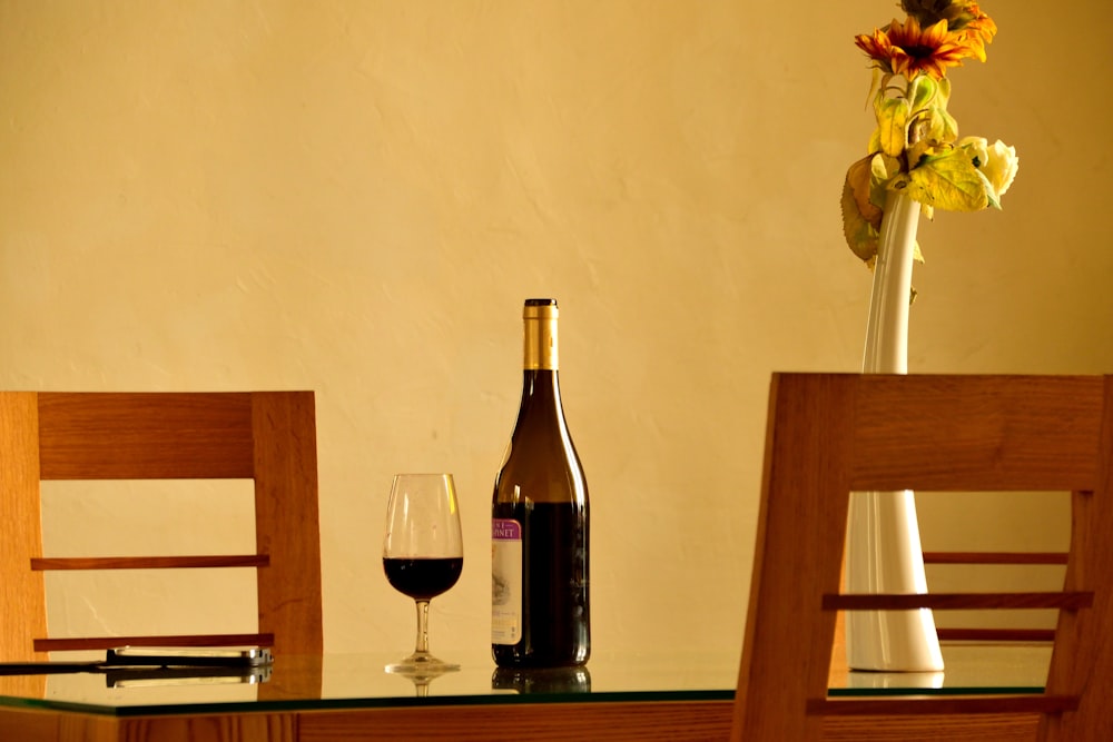 a glass of wine and a bottle of wine on a table