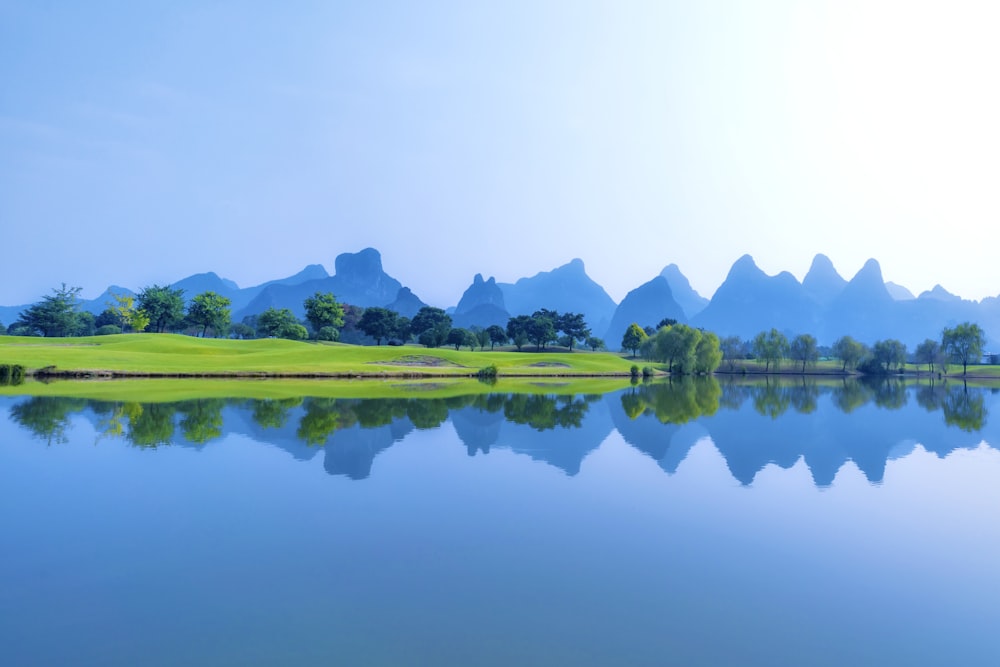 a scenic view of a golf course with mountains in the background