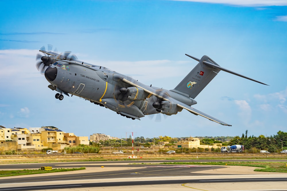 un avion militaire volant à basse altitude au-dessus d’une piste