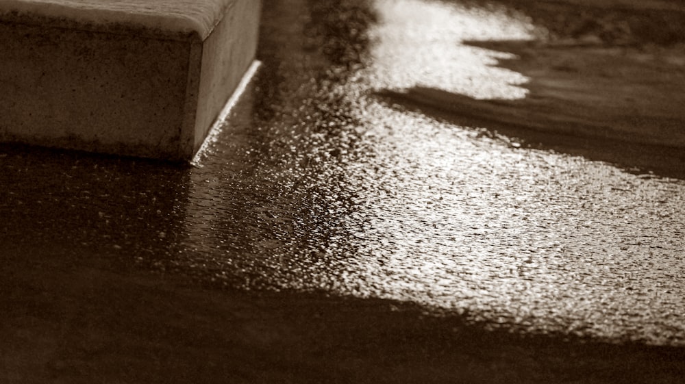 a bench sitting on the side of a wet street