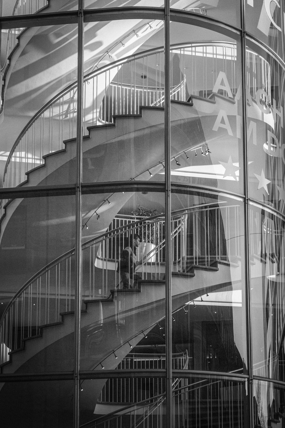 a spiral staircase reflected in the glass of a building