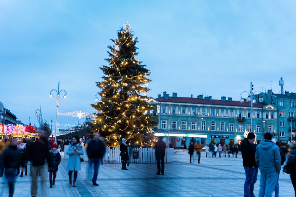 a group of people standing around a christmas tree